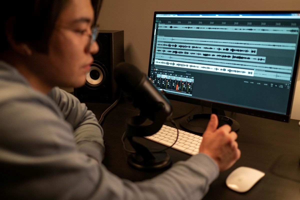 An audio engineer editing a podcast episode in a professional studio.