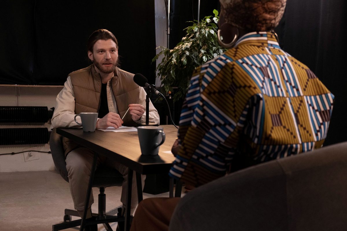 Two people recording a podcast interview in a studio.