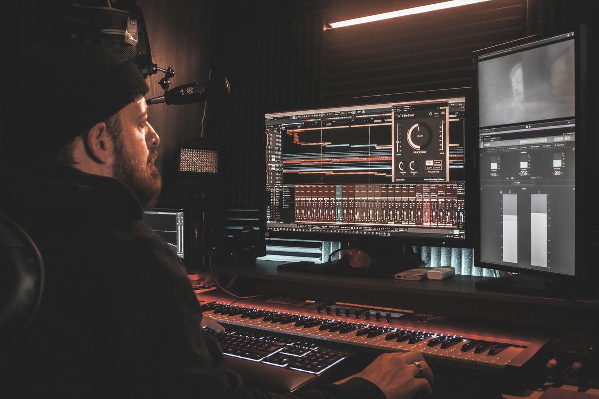 An audio engineer editing a podcast in a professional studio.