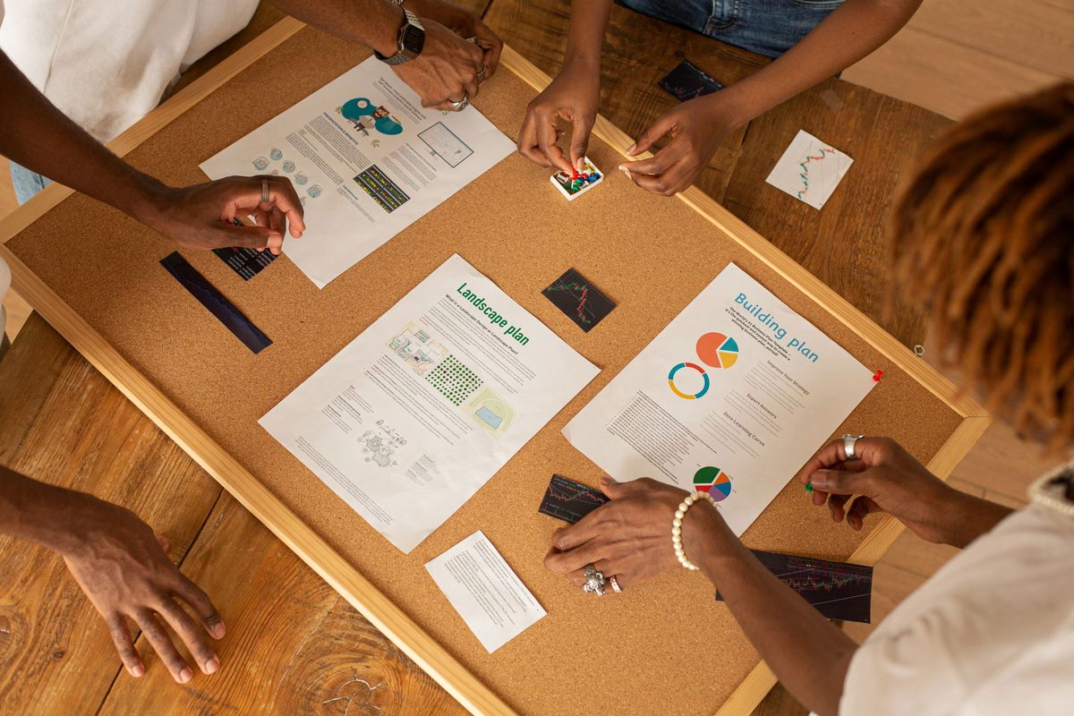 A team reviewing project plans and charts on a planning board.